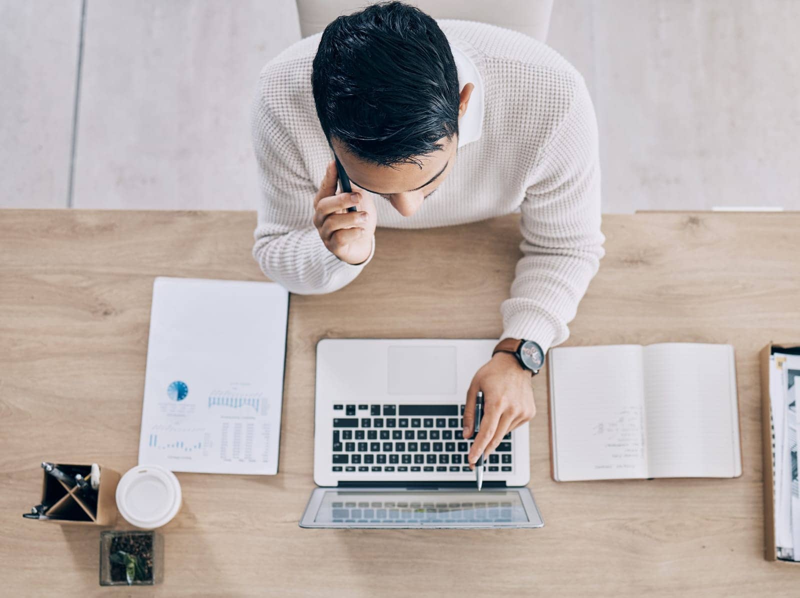 man working on his laptop while taking a call man working on his laptop while taking a call